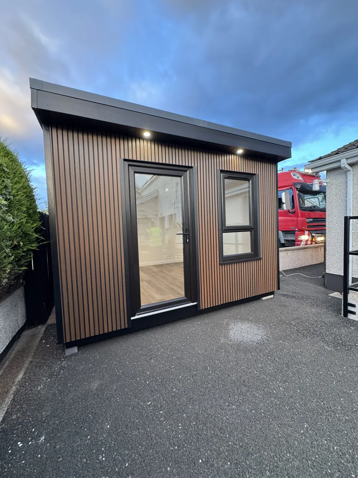 Timber-clad garden room with glazed door and window